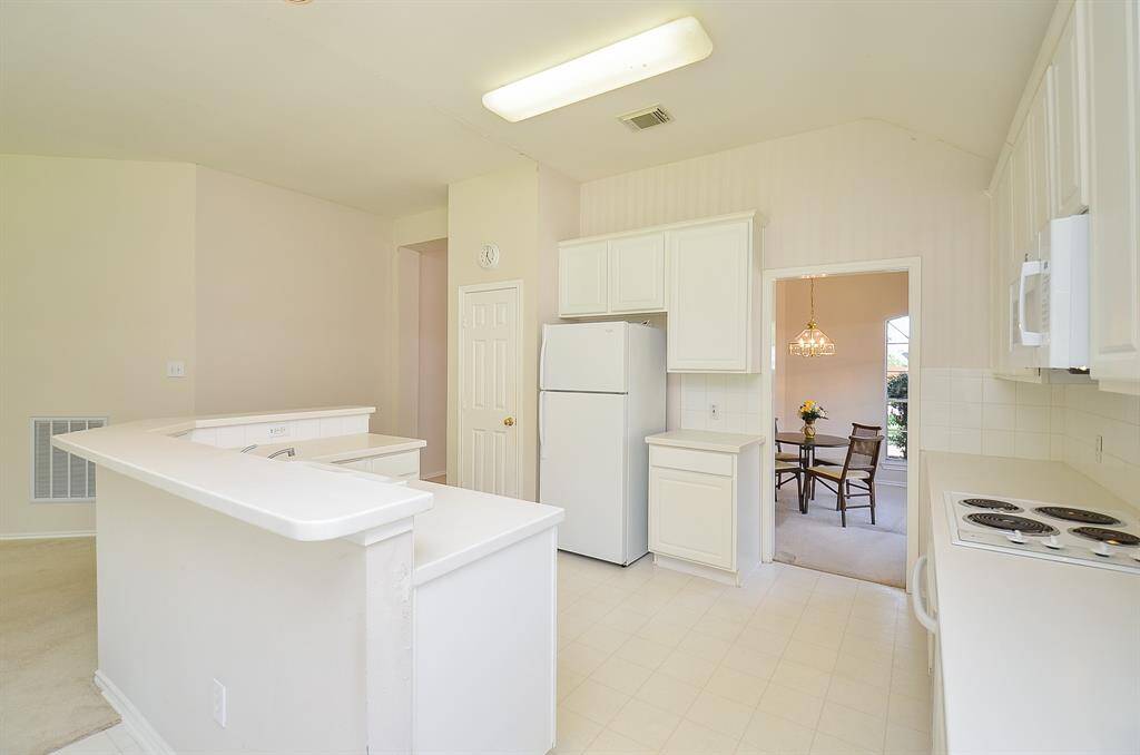 Bright kitchen with white cabinetry and appliances