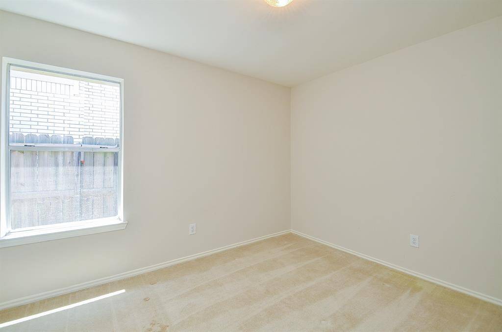 This bright bedroom with neutral walls and carpet, featuring a window that lets in natural light. Ideal for a cozy bedroom.
