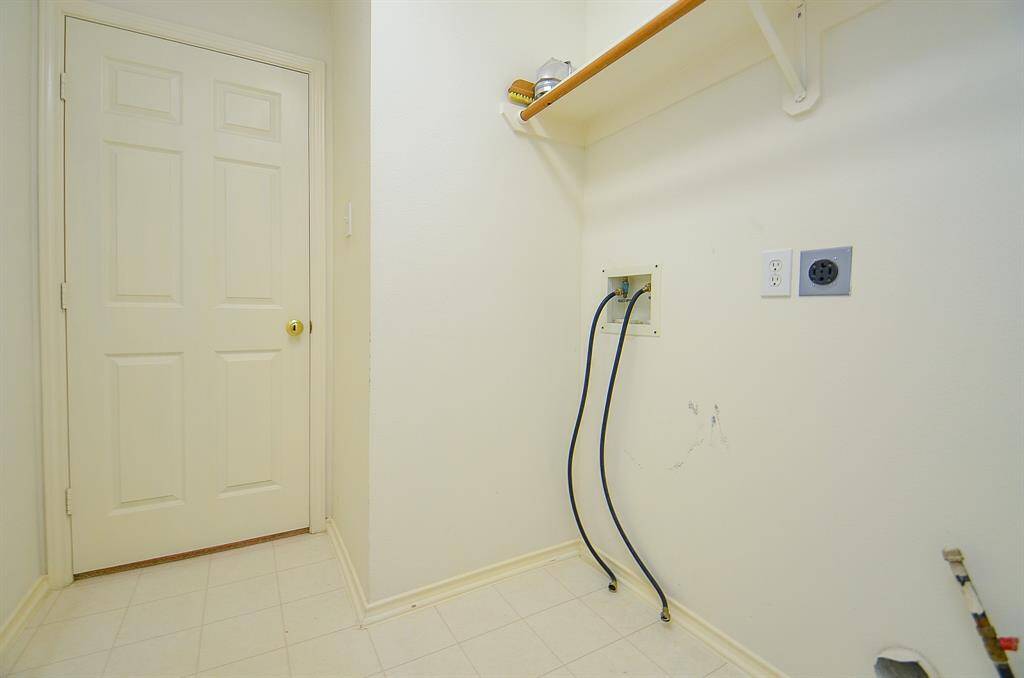 This laundry room offers hookups for a washer and dryer, a door to the garage.