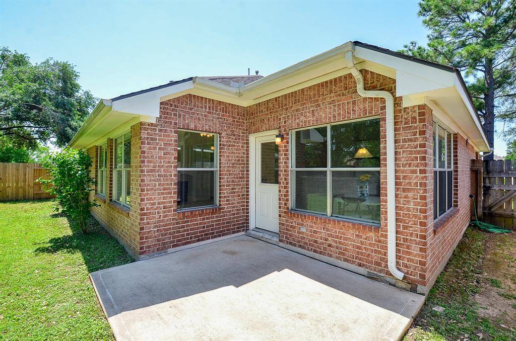 Charming back patio surrounded by a large yard. Features large windows for natural light and a cozy outdoor space perfect for relaxation.