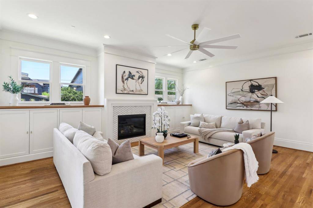 White Oak flanks the top of the cabinetry in the family room. Plenty of storage is provided, and everything is centered around a gorgeous fireplace. East-facing windows drink in the light, taking full advantage of the corner lot.