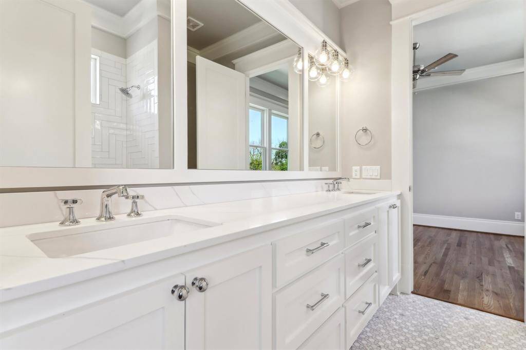Shared secondary bathroom with double sinks and tons of storage.