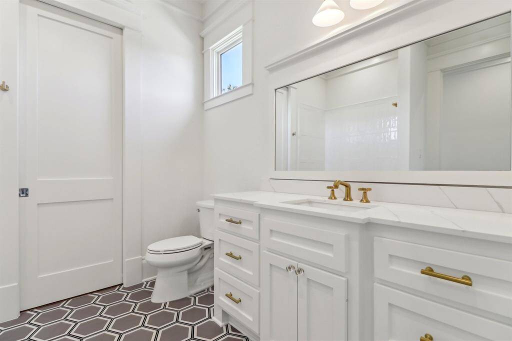 En suite secondary bathroom / hex tile flooring with gold fixtures make this a gorgeous space!