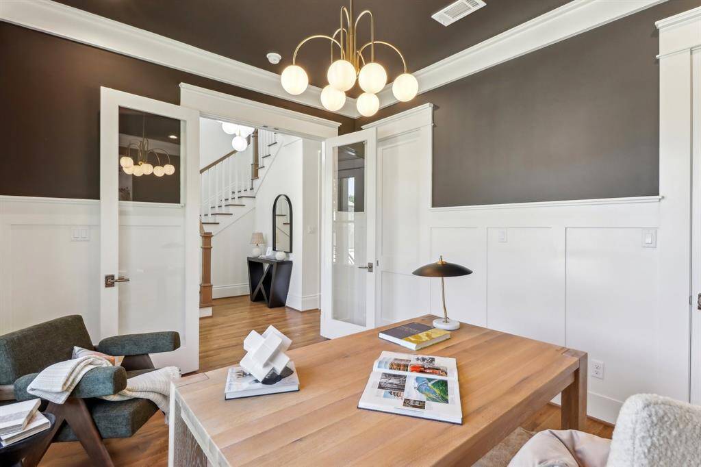 Single lite doors off the main foyer lead to this inviting workspace.