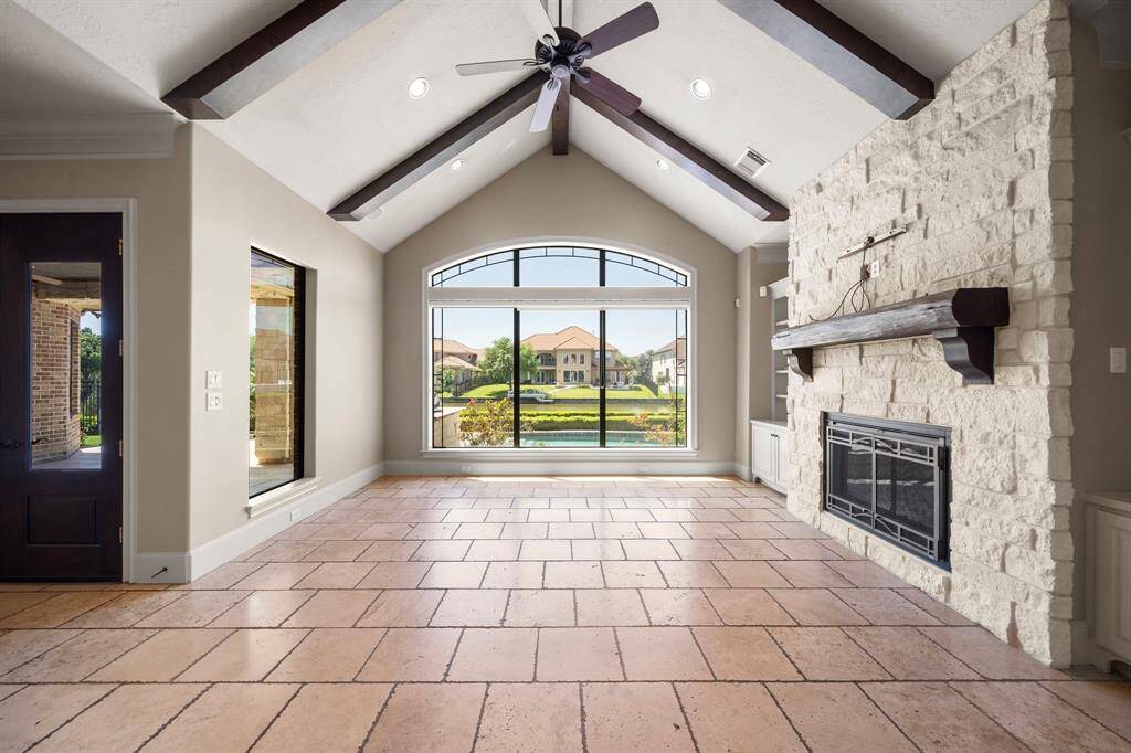 Kitchen is open to family room with access to covered patio and a secondary bedroom on the right.