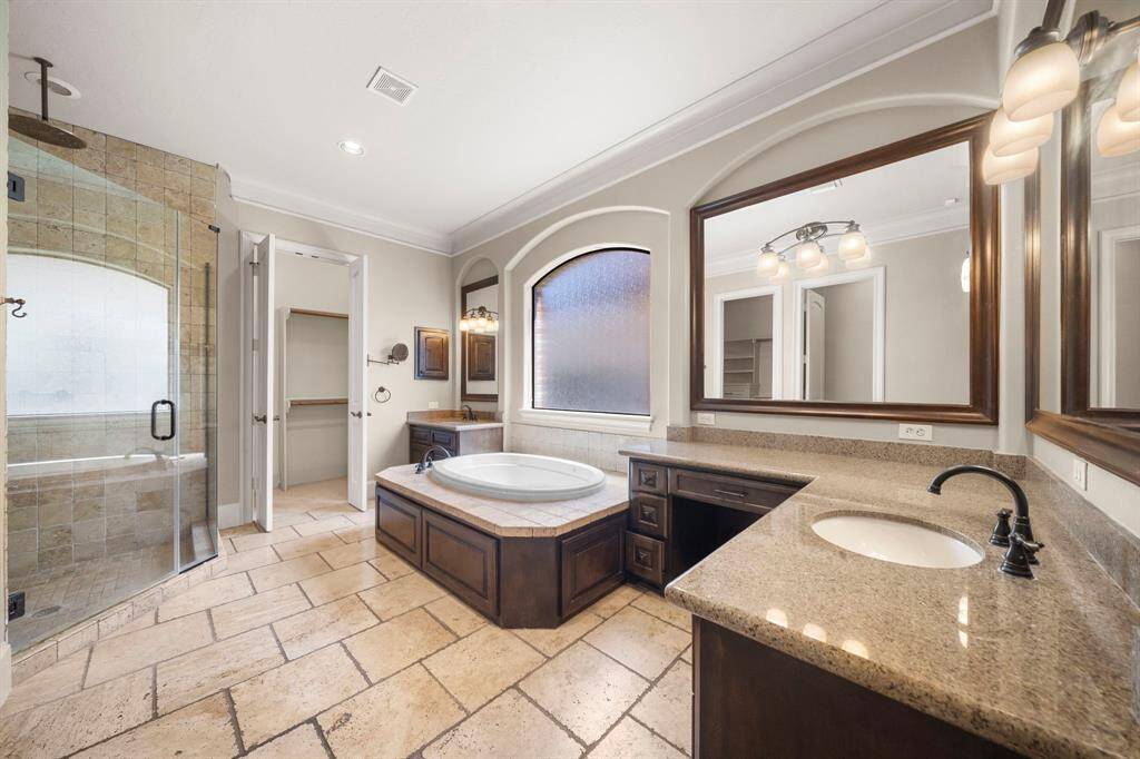 Primary bath, separate jetted tub, large walk in shower, vanity and 2 sinks and 2 large walk in closets
