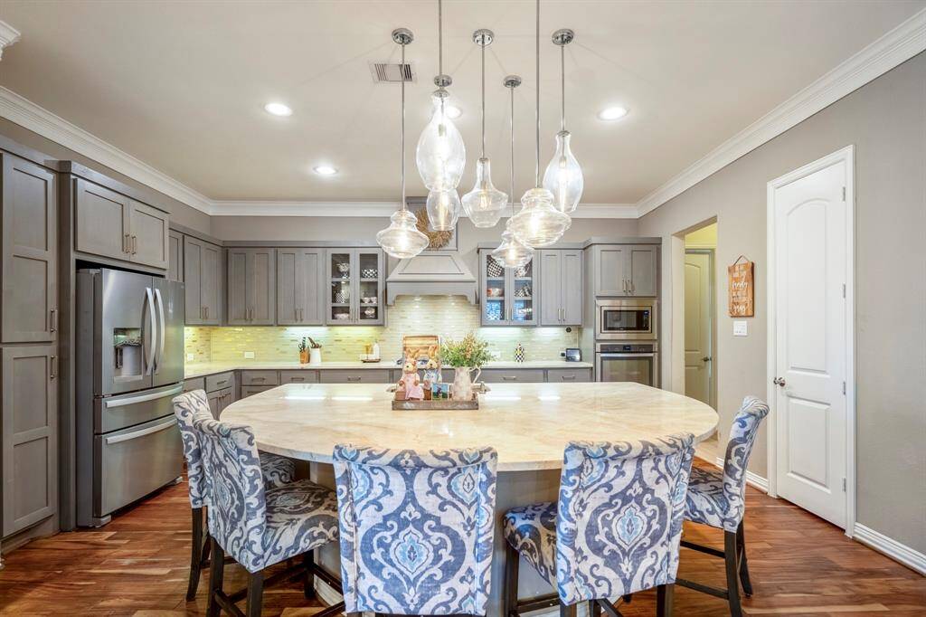 Multiple pendant light fixtures, complete with teardrops, accentuates the ceiling and lends drama to the island space.