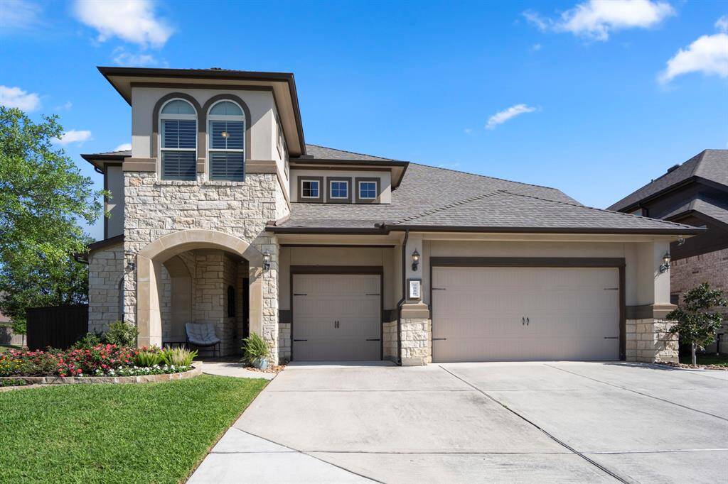 Gorgeous stacked stone elevation with arched opening to the covered front porch, notice the 3 car garage and dual driveway.