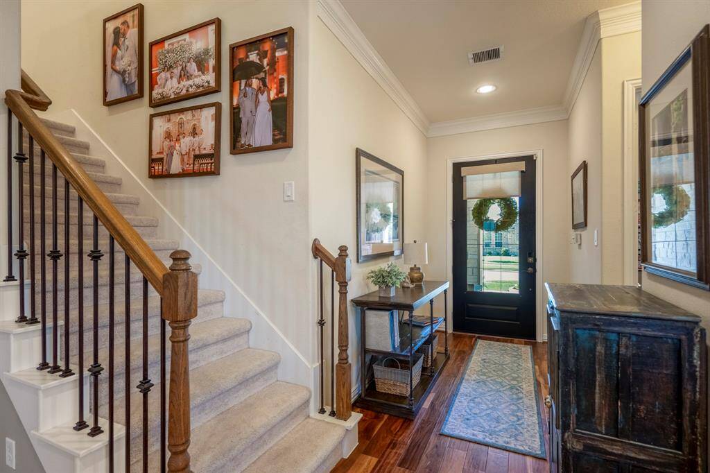 A traditional staircase, with traditional handrail, and wrought iron spindles lead to the second floor of the home.