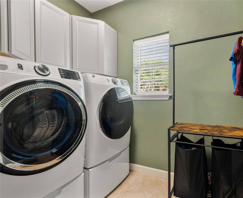 The laundry room is conveniently located near the Kitchen and has extra storage cabinets installed above washer/dryer.
