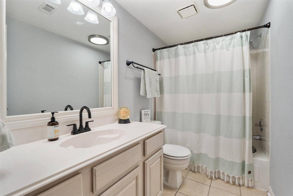 This full bath to the left of the stairway has an updated faucet with matching towel rack for a fresh look.