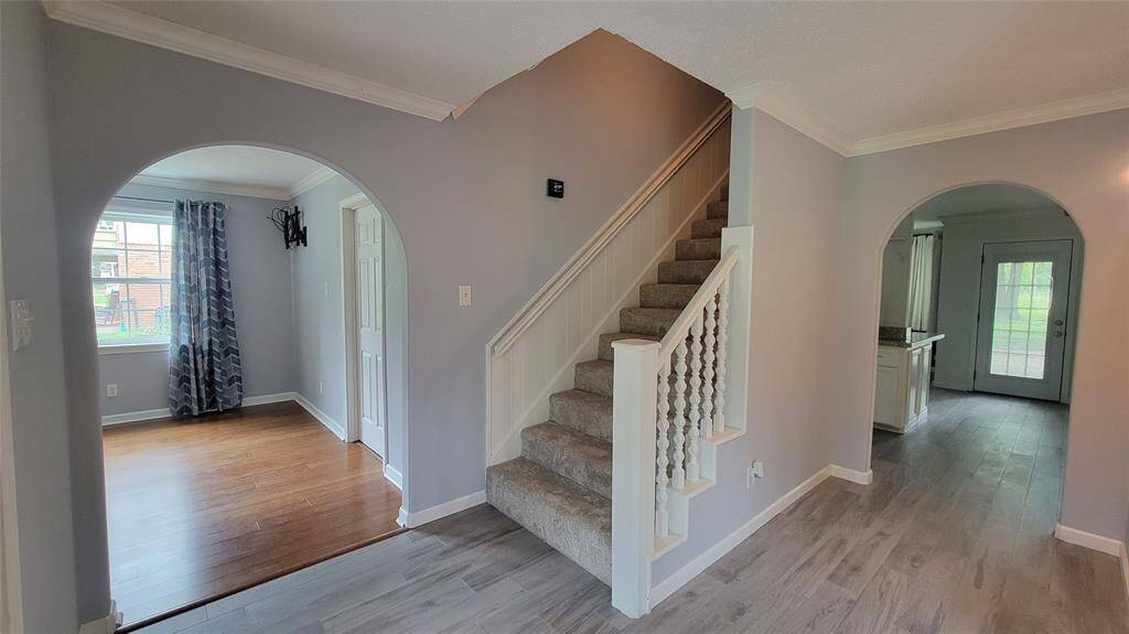 The foyer with arched doorways to the formal dining room, family room, and game room (to the right).