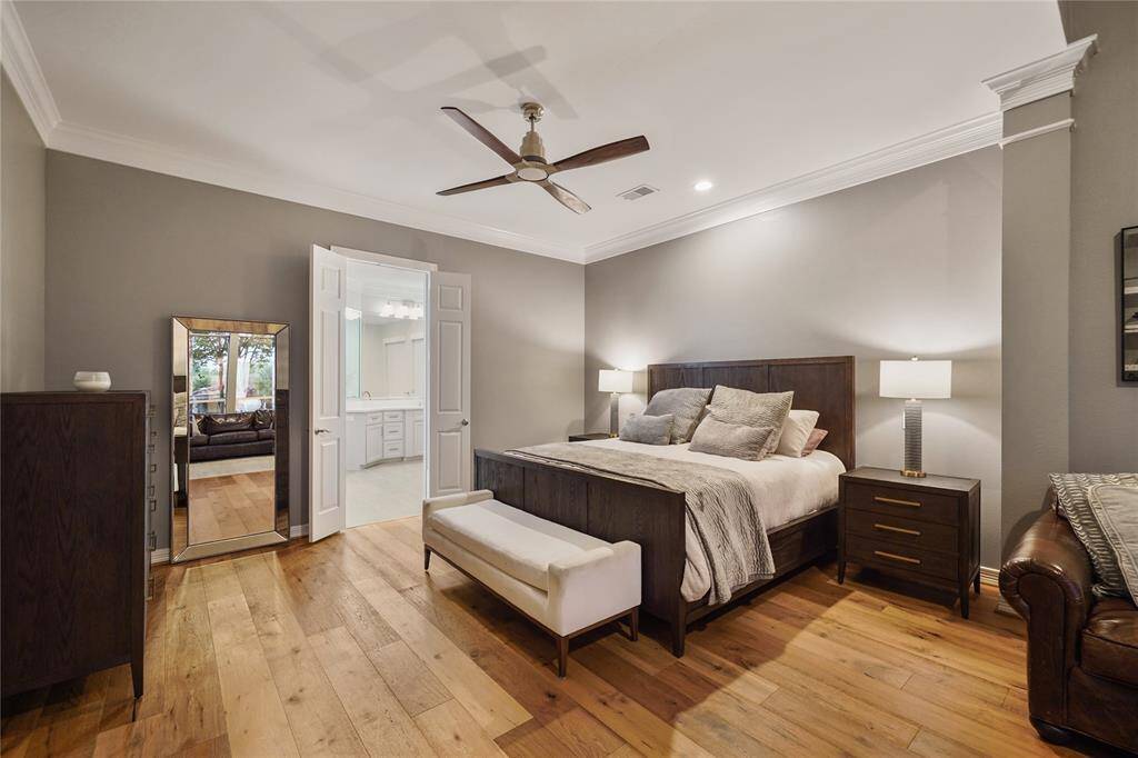 The owner's suite offers a peaceful retreat, featuring a sitting area, tall windows with custom electric blackout drapes for ultimate privacy and comfort, and a cozy fireplace to create an inviting ambiance.