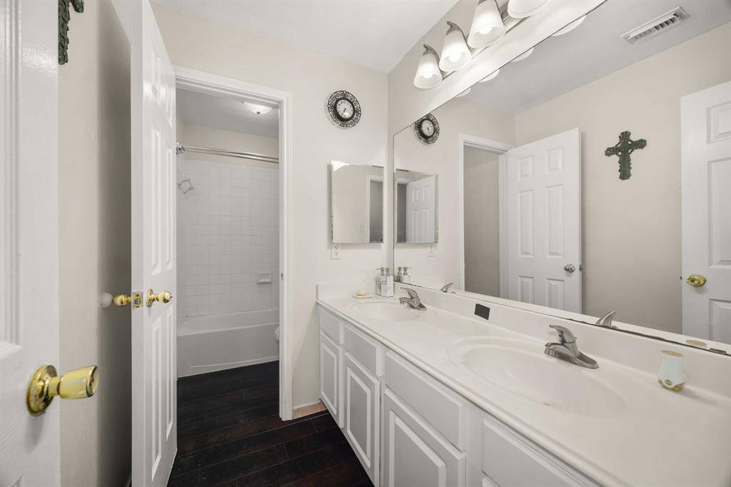 Well-appointed secondary bedroom with dual sinks, ample counter space, and a separate shower/tub combo - perfect for guests or shared use.