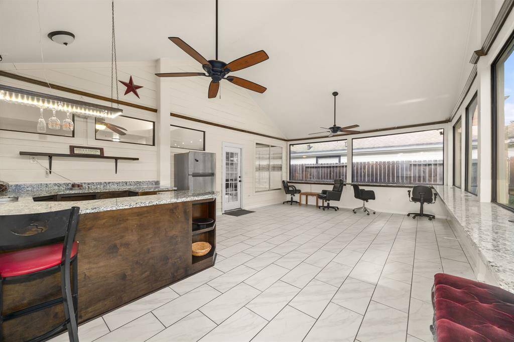 Turn up the vibes in this oversized sunroom complete with a built-in bar, granite countertops, and room to entertain, relax, or convert into your dream flex space.