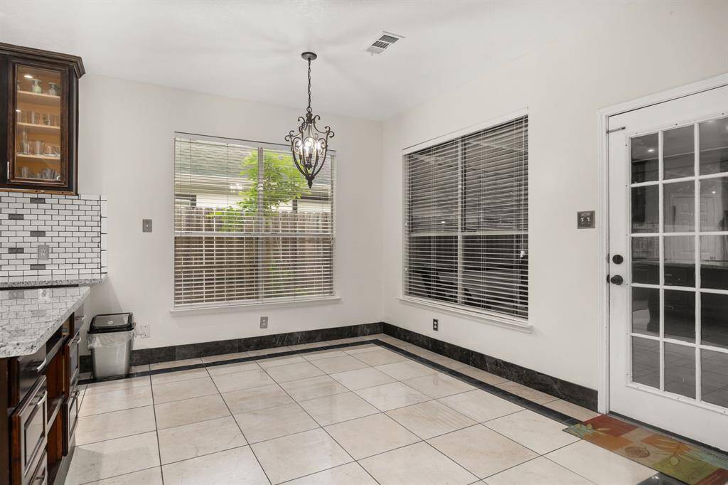 Natural light pours into this charming breakfast nook, featuring Italian marble flooring, custom trim, and direct access to the patio, wet bar and backyard - ideal for casual dining or morning coffee vibes.
