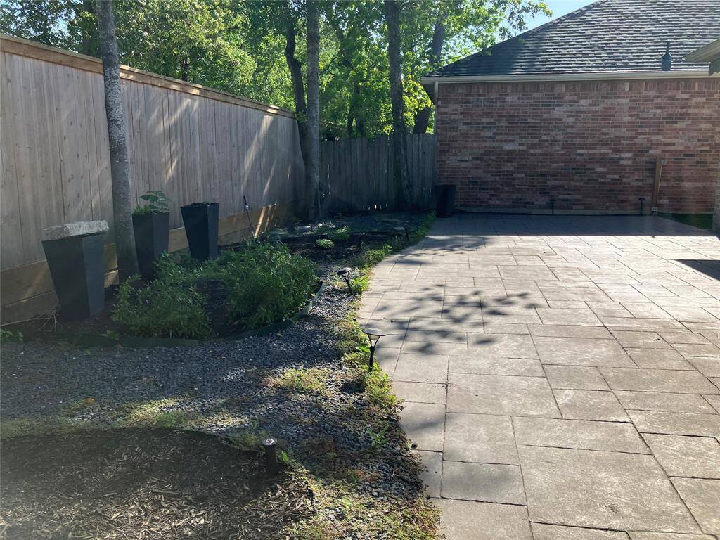 Enormous hard surface patio with remote control awning, edged with beautifully designed gravel and planter beds.  Truly carefree.