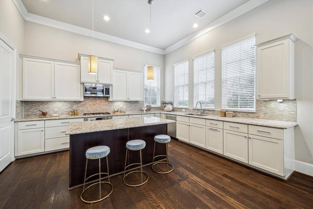 The kitchen has an island with space for seating and quartz countertops.