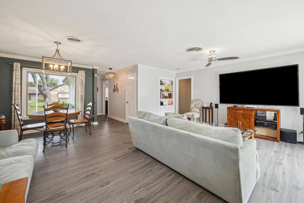The open-concept living and dining areas offer plenty of space for gathering, with updated flooring and fresh neutral tones.