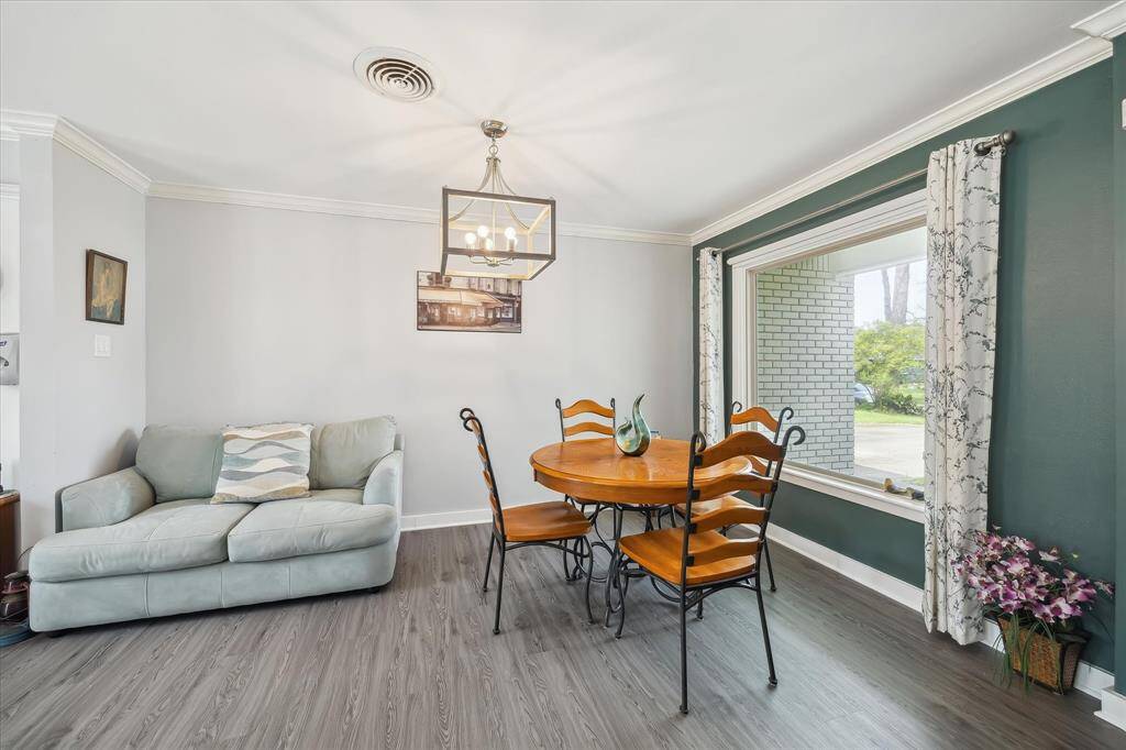 The light-filled dining area sits off the foyer and kitchen, highlighted by updated lighting and front-facing window views.