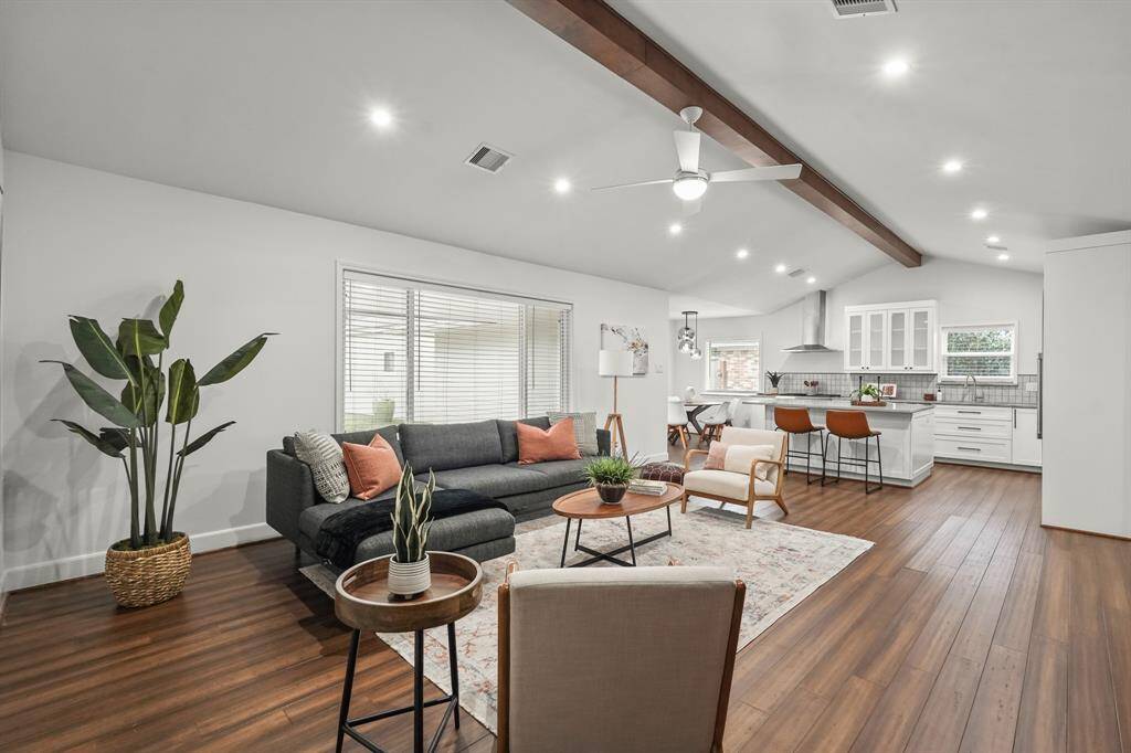 Welcome to 9815 Knoboak Dr. The inviting Family Room open to the Kitchen, features lovely hardwood floors, modern ceiling fan, inset lighting & a stunning wood beam ceiling, creating a warm & relaxed atmosphere.