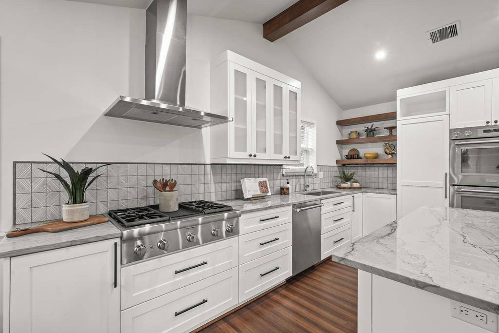 A 5-burner gas stove & modern vent hood — this space is ideal for creating culinary masterpieces. The updated cabinetry offers ample storage space and pot drawers for all your cooking essentials.