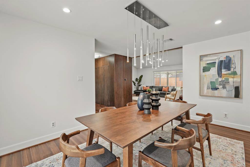 Formal Dining Room features a gorgeous modern chandelier, inset lighting & hardwood floors. The seamless flow between the Dining Room & Family Room is perfect for hosting guests & enjoying everyday family time.