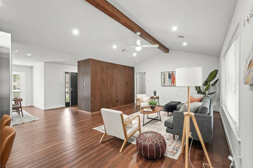 The heart of the home, the Family Room, showcases a beautiful wood beam ceiling and recently added Bamboo flooring all paired with a modern vertical wood slat design, adding rustic elegance & a touch of contemporary flair.