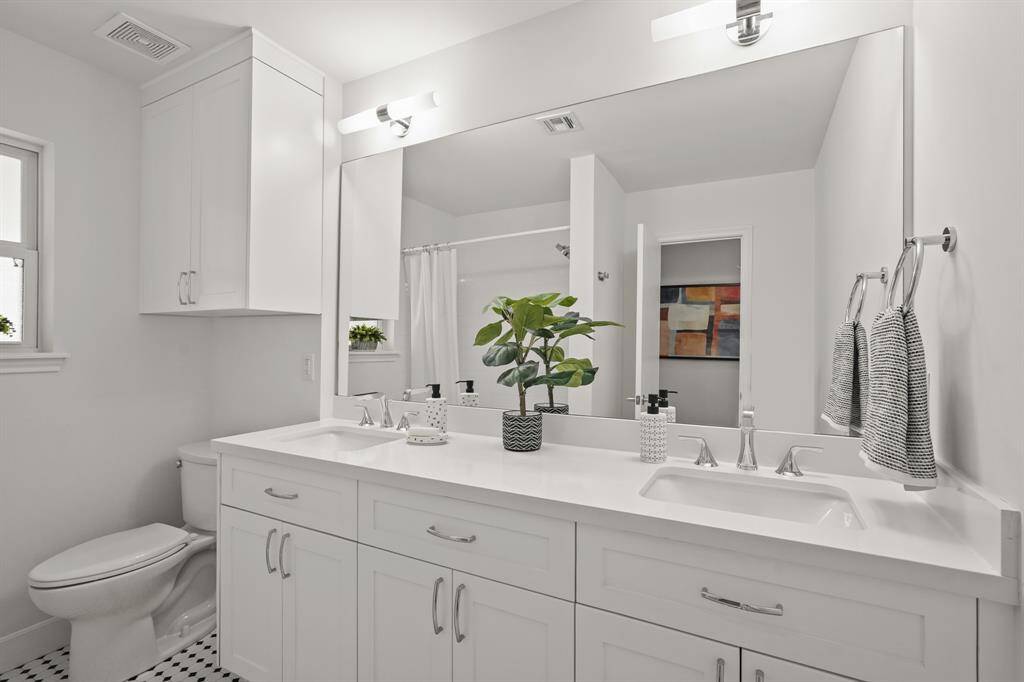 The bright & updated Secondary Bathroom features a sleek vanity, updated light fixtures offering comfort & functionality for family or guests.