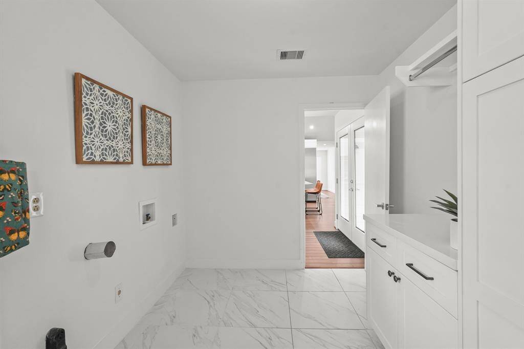The large Utility Room, conveniently located just off the Kitchen, is designed for both functionality & organization.