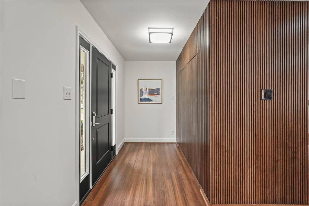 The recently widened and updated Front Door leads into a space where the vertical wood slat walls enhance the sense of depth & character, providing a modern yet warm atmosphere & an inviting focal point. Plus, this area provides abundant storage space behind the wood.