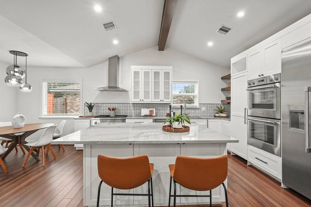 This kitchen was recently redesigned and opened up to the living area, seller added this large island with extra storage cabinets. The open layout that seamlessly connects to the Breakfast Area & Family Room. Recently added Thermador Built-in refrigerator/freezer and double ovens. Be sure to check out the hidden walk-in pantry beside the ovens.