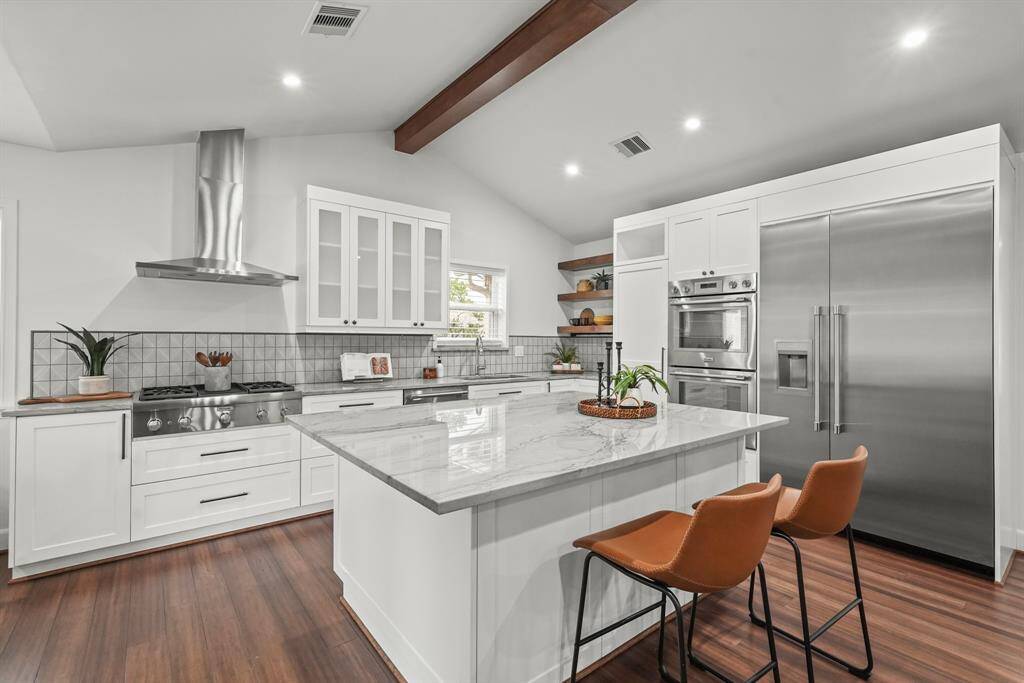 Kitchen is a true chef’s paradise, featuring quartzite countertops, a large island, high-end Thermador appliances, including a double oven, undercabinet microwave, over sized refrigerator with Freezer, a 5-burner gas stove, & a sleek vent hood above. A beautiful tile backsplash adds a touch of elegance & ties the space together.