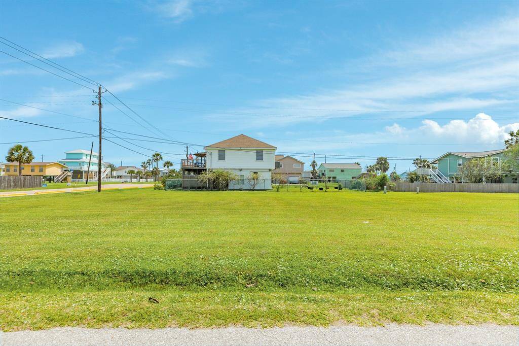 A clear view from the street, showing the wide frontage of the corner lot and the well-maintained neighboring homes.