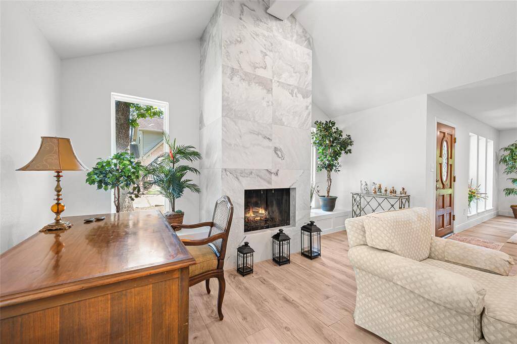 Fireplace with two windows allowing natural light to pour through the home!