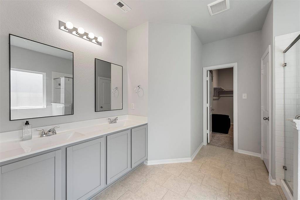 Relax and unwind in the luxurious primary bath featuring double sinks, a soaking tub, and a separate walk-in shower.