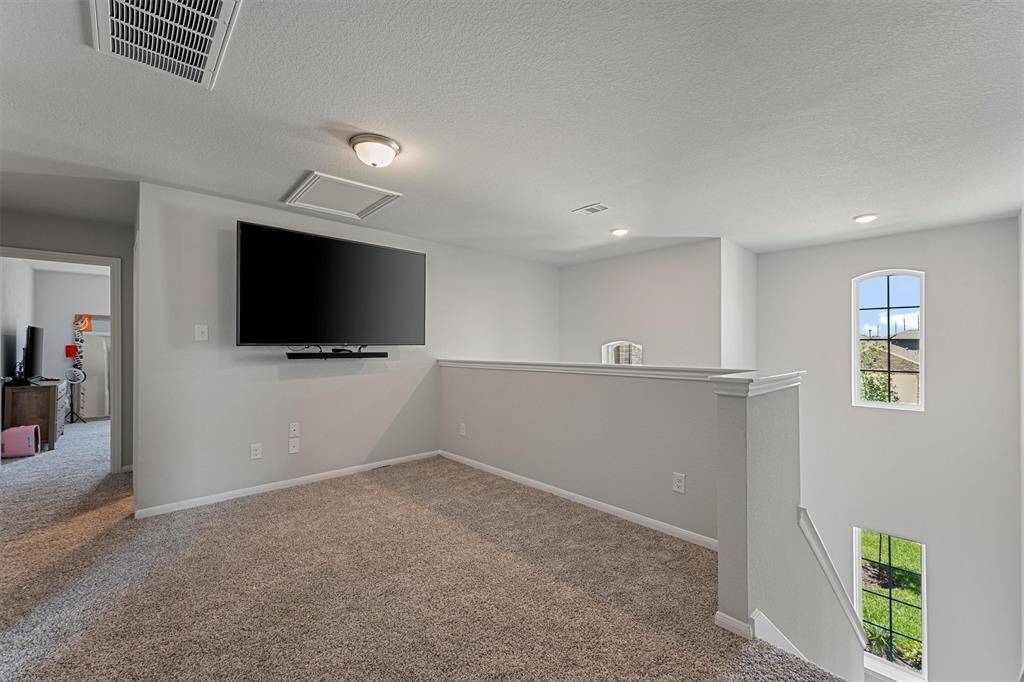 Upstairs game room with natural light and an open layout, perfect for a media space, playroom, or second living area.