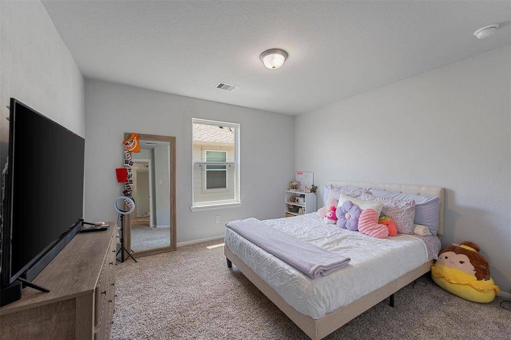 Upstairs secondary bedroom with  bright window offering natural light.