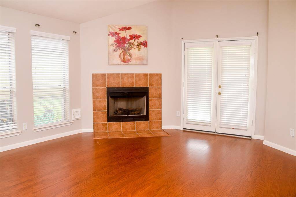 Living room with gas fireplace and nice window facing the back patio.