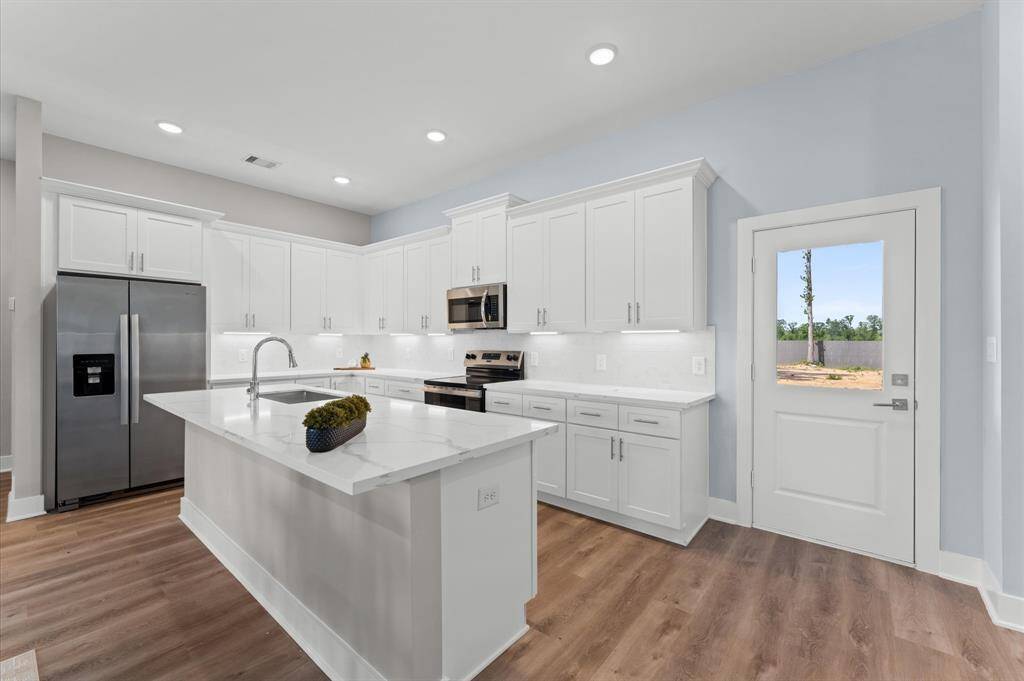 Stunning kitchen with quartz countertops, ample cabinetry, and stainless steel appliances included.