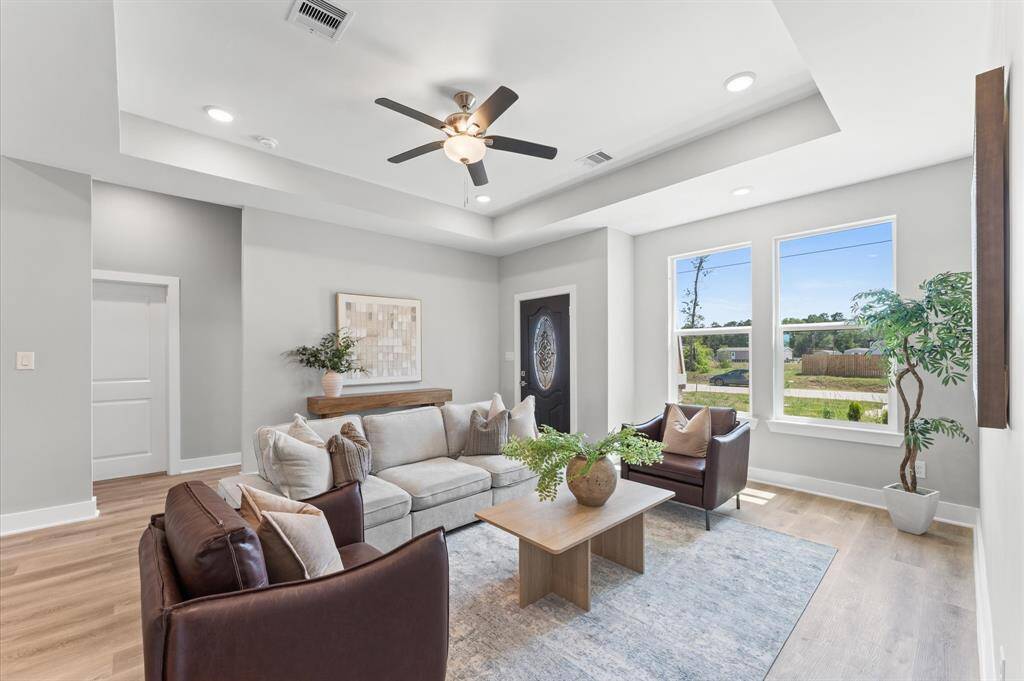 Open-concept living area featuring high ceilings, LED lighting, and plenty of natural light