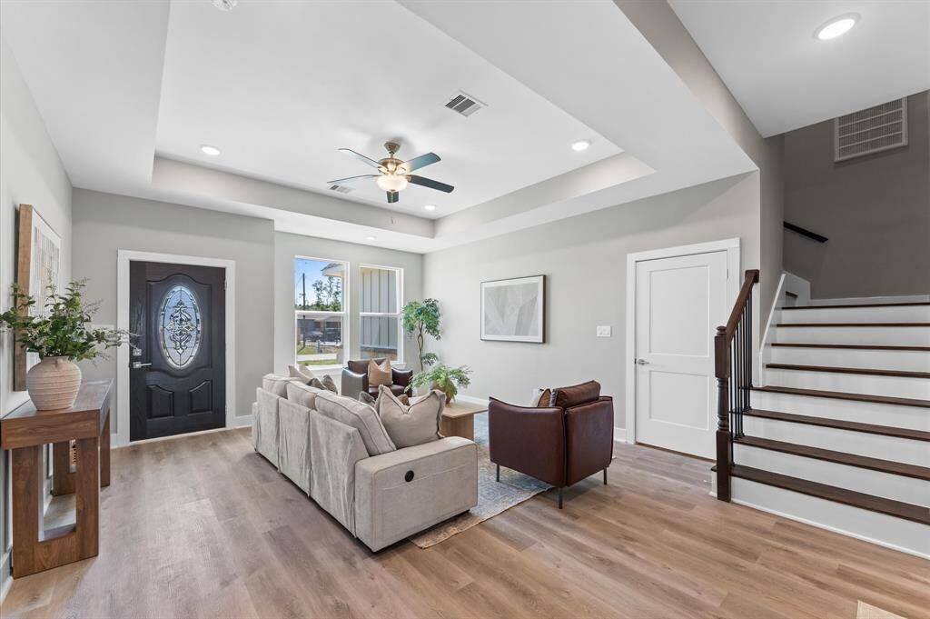Open-concept living area featuring high ceilings, LED lighting, and plenty of natural light