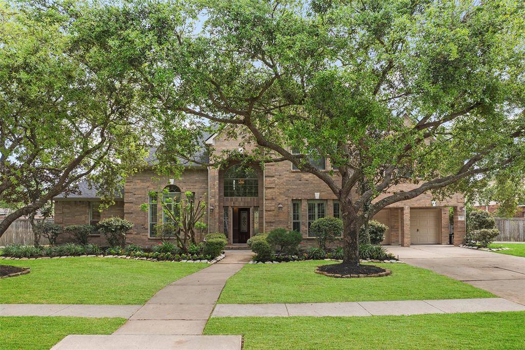Inviting front view with stunning mature trees.