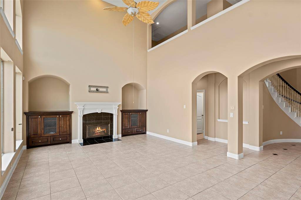 Another view of the spacious living room featuring elegant custom cabinetry with alcoves.