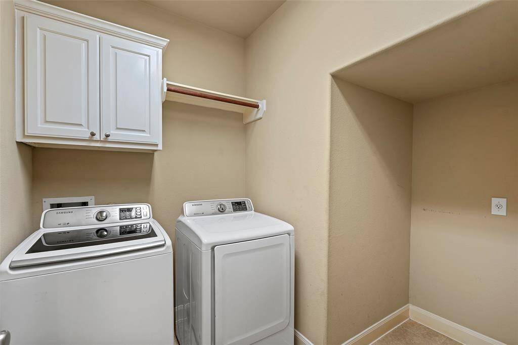 Convenient first-floor laundry room with ample storage and modern washer / dryer.