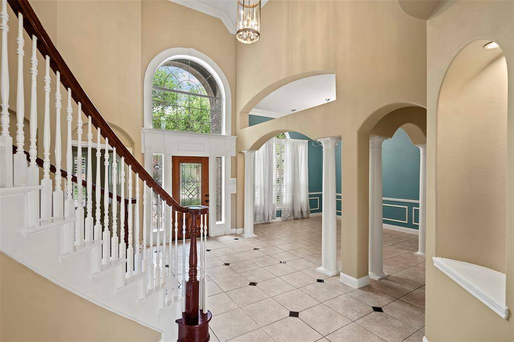 The stunning entryway which features arches, a balcony and alcove, take the grand staircase to the upper level.