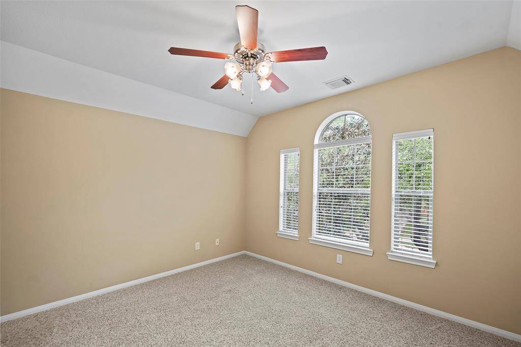 Bright, spacious room with large arched window with views of greenery.