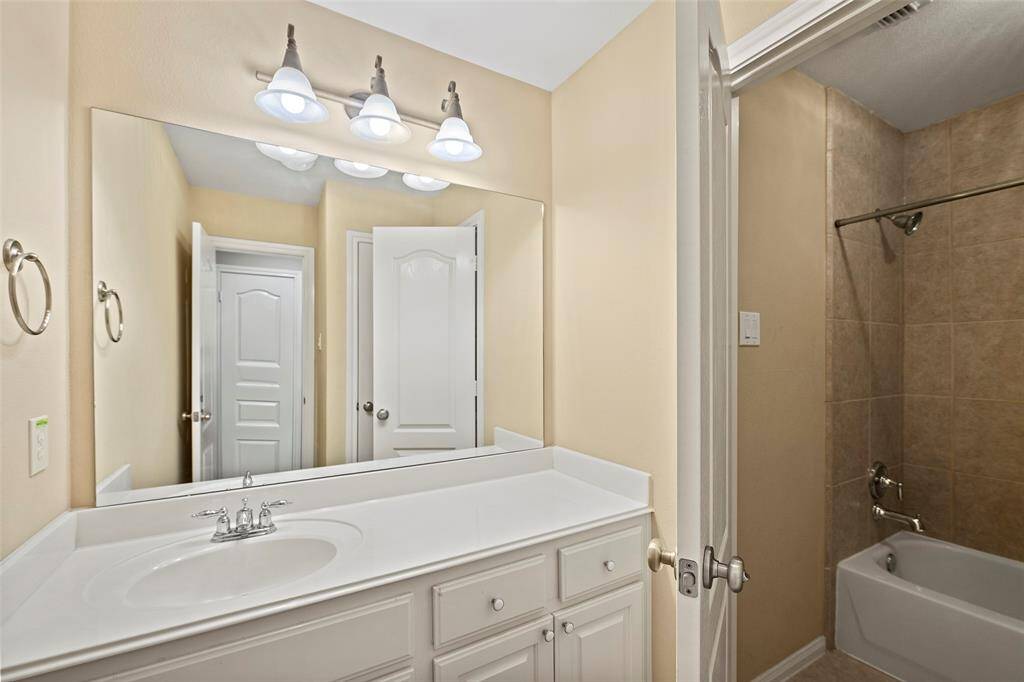 Spacious secondary Jack and Jill bathroom featuring modern fixtures, ample counter space, and a relaxing tub/shower combo.