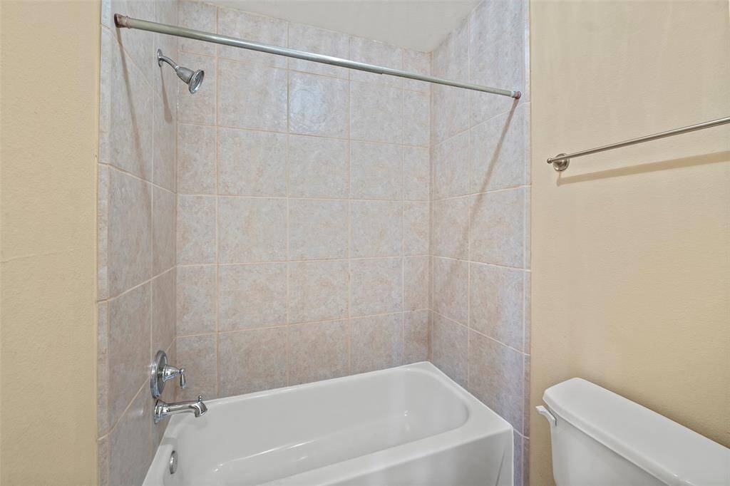 This bathroom features a tiled shower and tub for added convenience and comfort.