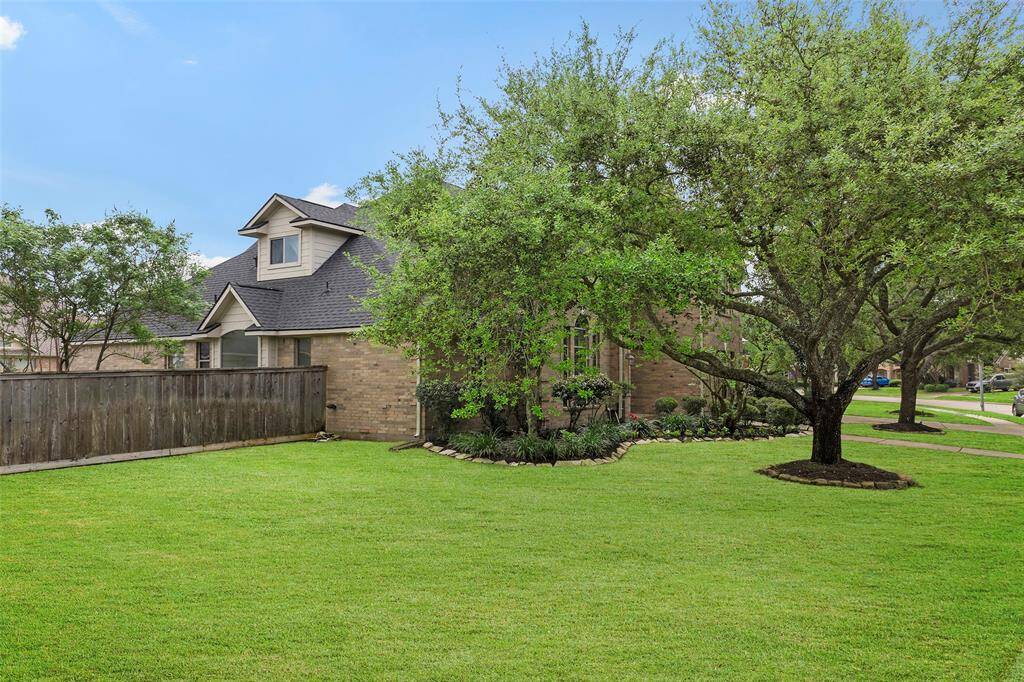 Discover tranquil living in this charming brick home with lush, tree-shaded lawn.